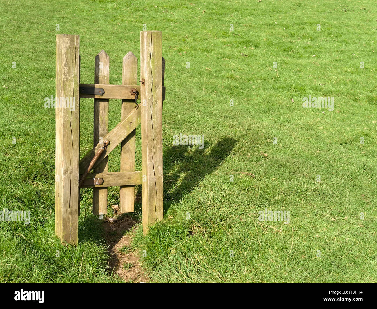 Sinnlose isolierte schmalen hölzernen Fußweg Tor zu nirgendwo in der Mitte der Wiese Stockfoto