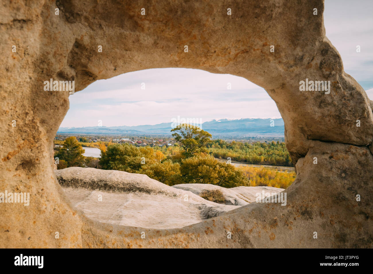 Uplistsikhe, Shida Kartli Region, Georgia. Blick auf Kvakhvreli Stadtbild durch natürliche Arch im berühmten Wahrzeichen. Alte Felsen gehauen Stadt im Osten Geo Stockfoto