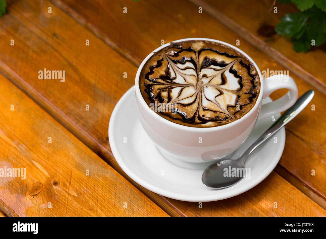 Kaffee Tasse Cappuccino. Heißen Cappuccino mit Zickzack Karamell auf Holz- Hintergrund. Stockfoto