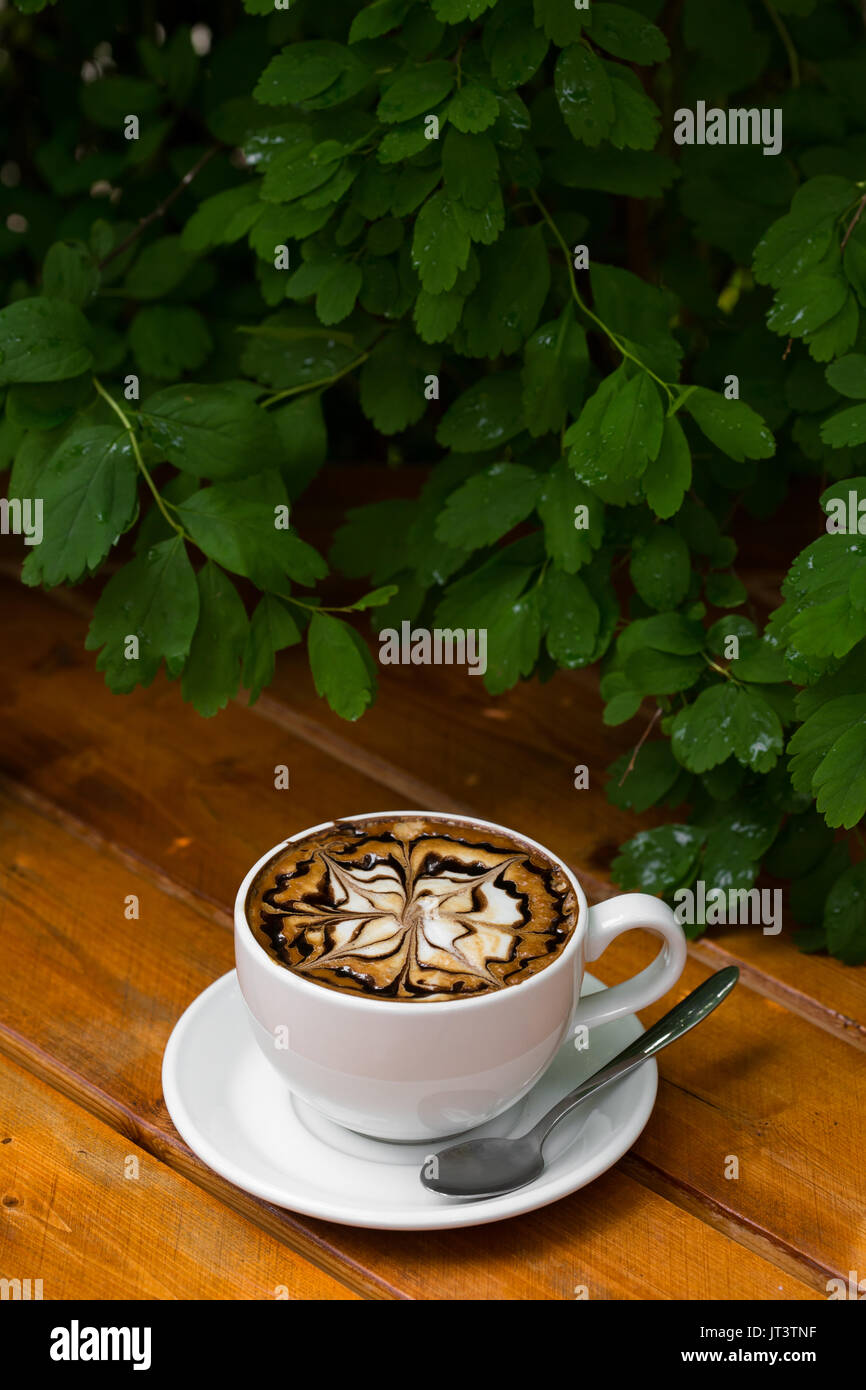 Kaffee Tasse Cappuccino. Heißen Cappuccino mit Zickzack Karamell auf Holz- Hintergrund. Stockfoto