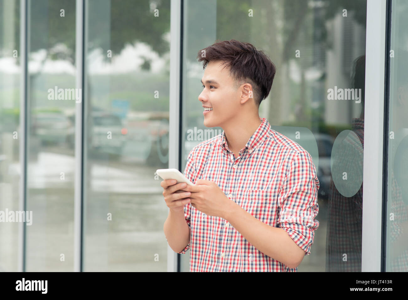 Jugendliche mit Handy außerhalb der Gebäude in der Stadt Stockfoto