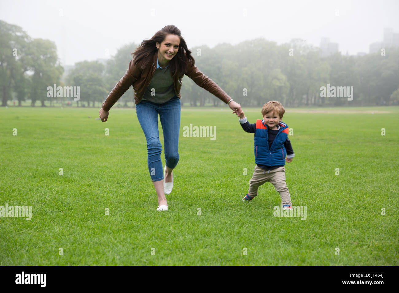 Glückliche Mutter spielt mit ihren Toddler Sohn im Freien. Liebe und Zweisamkeit Konzept. Stockfoto