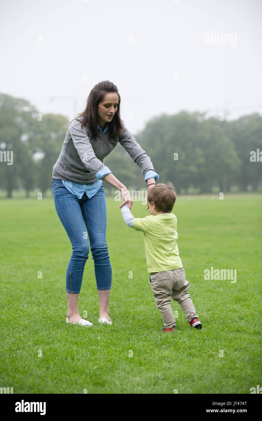 Glückliche Mutter spielt mit ihren Toddler Sohn im Freien. Liebe und Zweisamkeit Konzept. Stockfoto