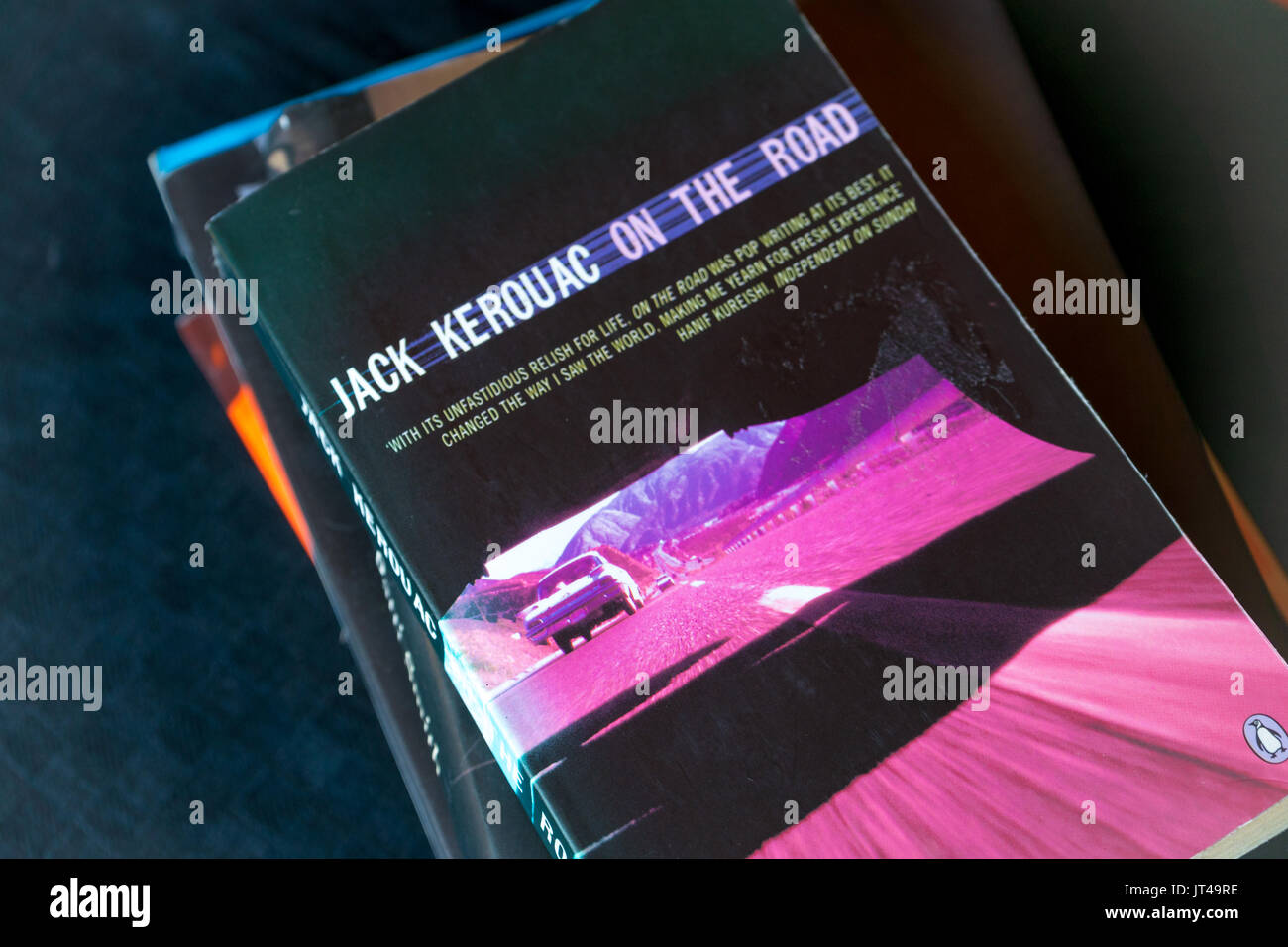 Eine Kopie der legendären Roman "On the Road" von Jack Kerouac oben auf einem Stapel Bücher Stockfoto