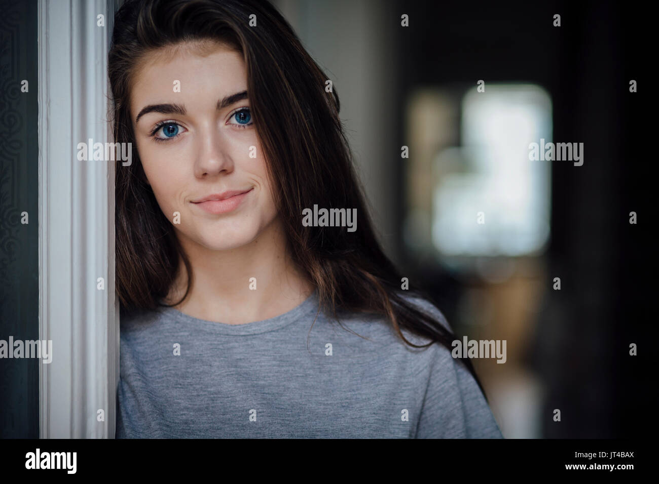 Porträt von einem schönen Mädchen im Teenageralter. Sie hat ihren Kopf gegen den Türrahmen. Stockfoto