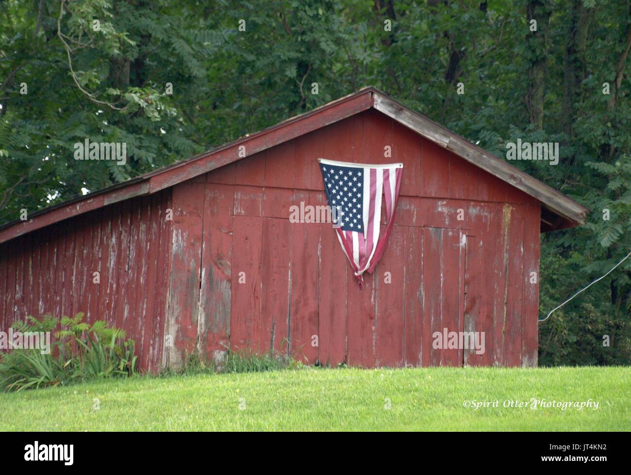 Verwitterte rote Scheune mit amerikanischer Flagge Stockfoto