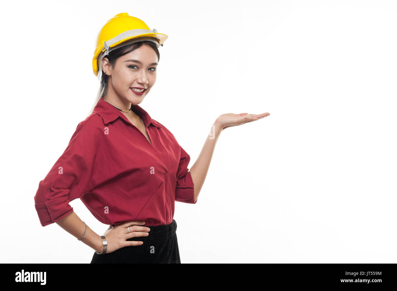 Asiatische Frau Ingenieur im roten Hemd und gelbe Schutzkappe Lächeln und zeigt Palm Hand. Menschen gestikulieren im Geschäft und enginerring Konzept Stockfoto