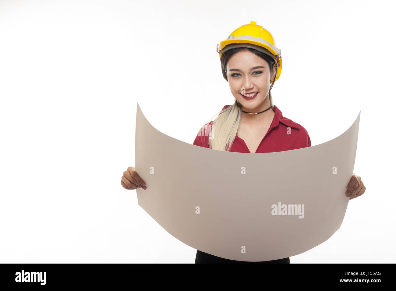 Junge asiatische Frau Architekt mit roten Hemd und gelben Helm Lächeln beim Lesen Blaupausen. industriellen Beruf Personen Konzept Stockfoto