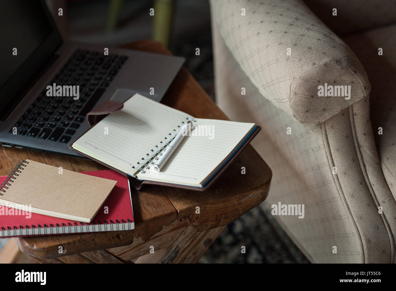 Pen, Notebooks und Laptop auf kleinen hölzernen Tisch. zu Hause arbeiten am Wochenende Konzept Stockfoto