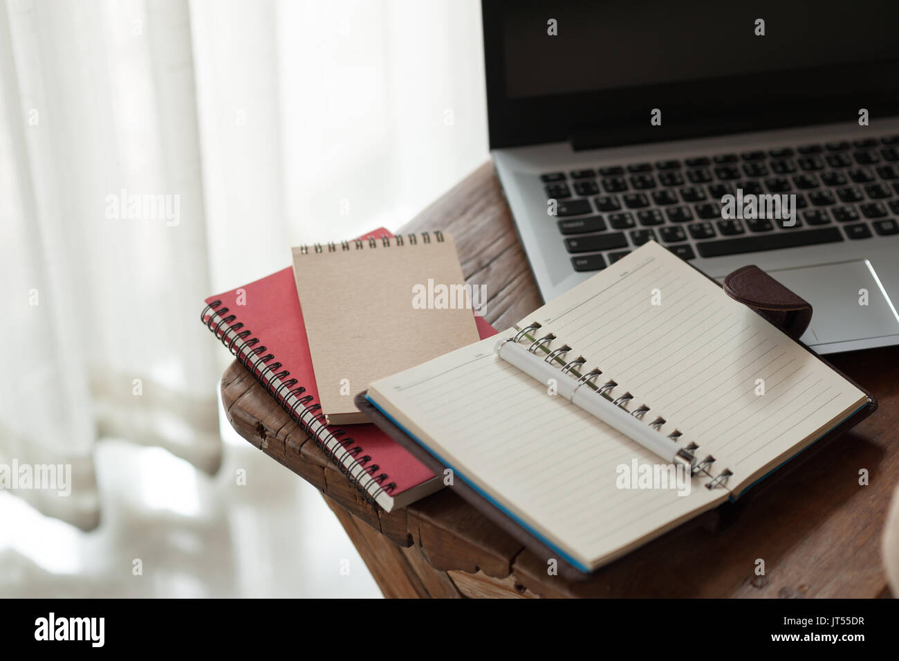 Pen, Notebooks und Laptop auf kleinen hölzernen Tisch. zu Hause arbeiten am Wochenende Konzept Stockfoto