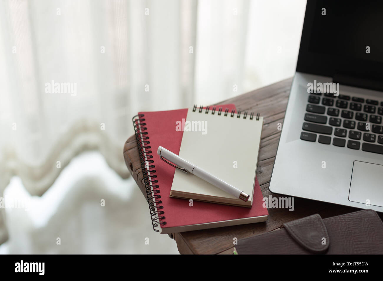 Pen, Notebooks und Laptop auf kleinen hölzernen Tisch. zu Hause arbeiten am Wochenende Konzept Stockfoto