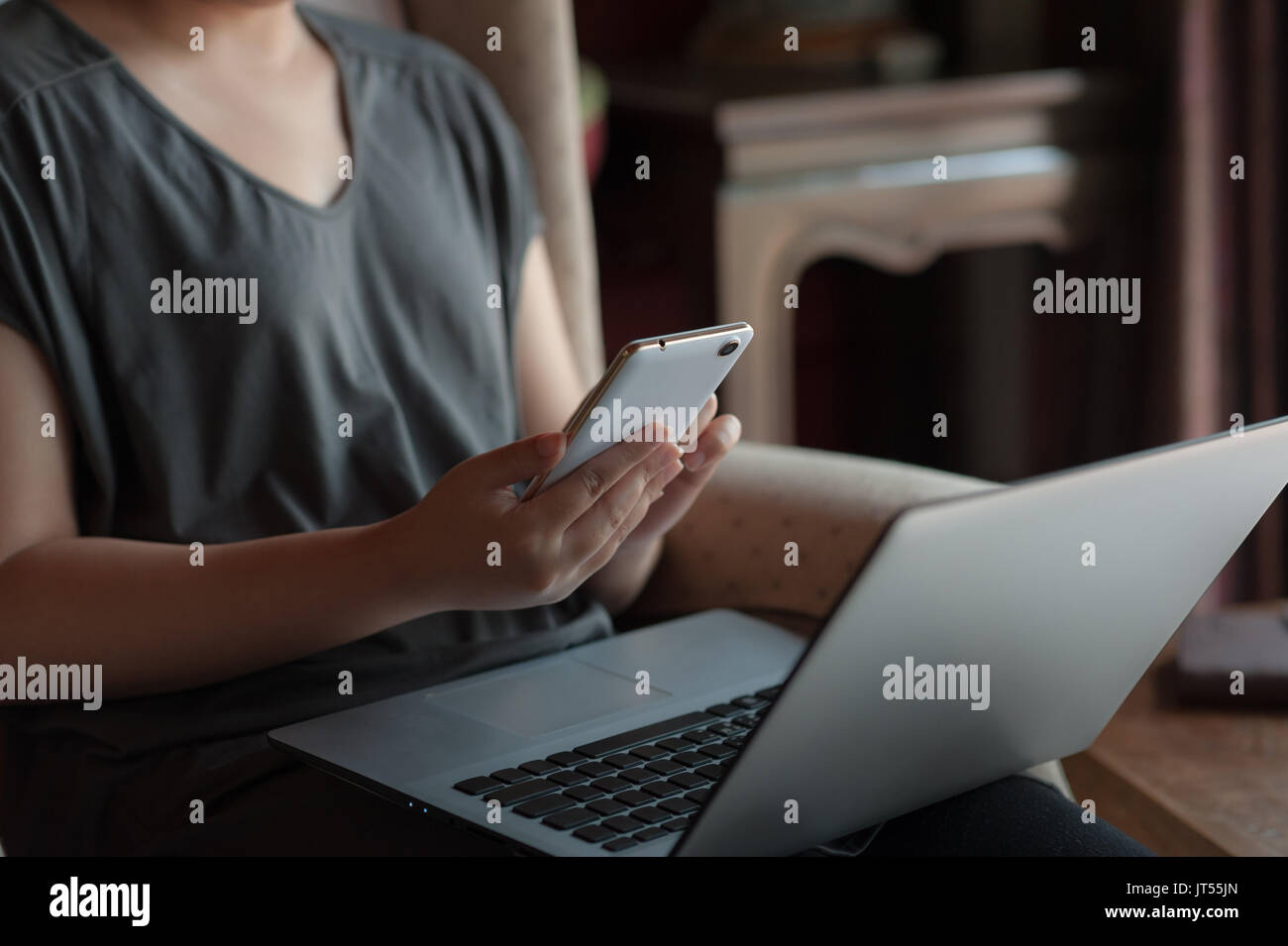 Frau freier Mitarbeiter mit Smartphone für soziales Netzwerk während der Arbeit mit dem Laptop. on-line-Geschäft und Self-concept beschäftigt Stockfoto