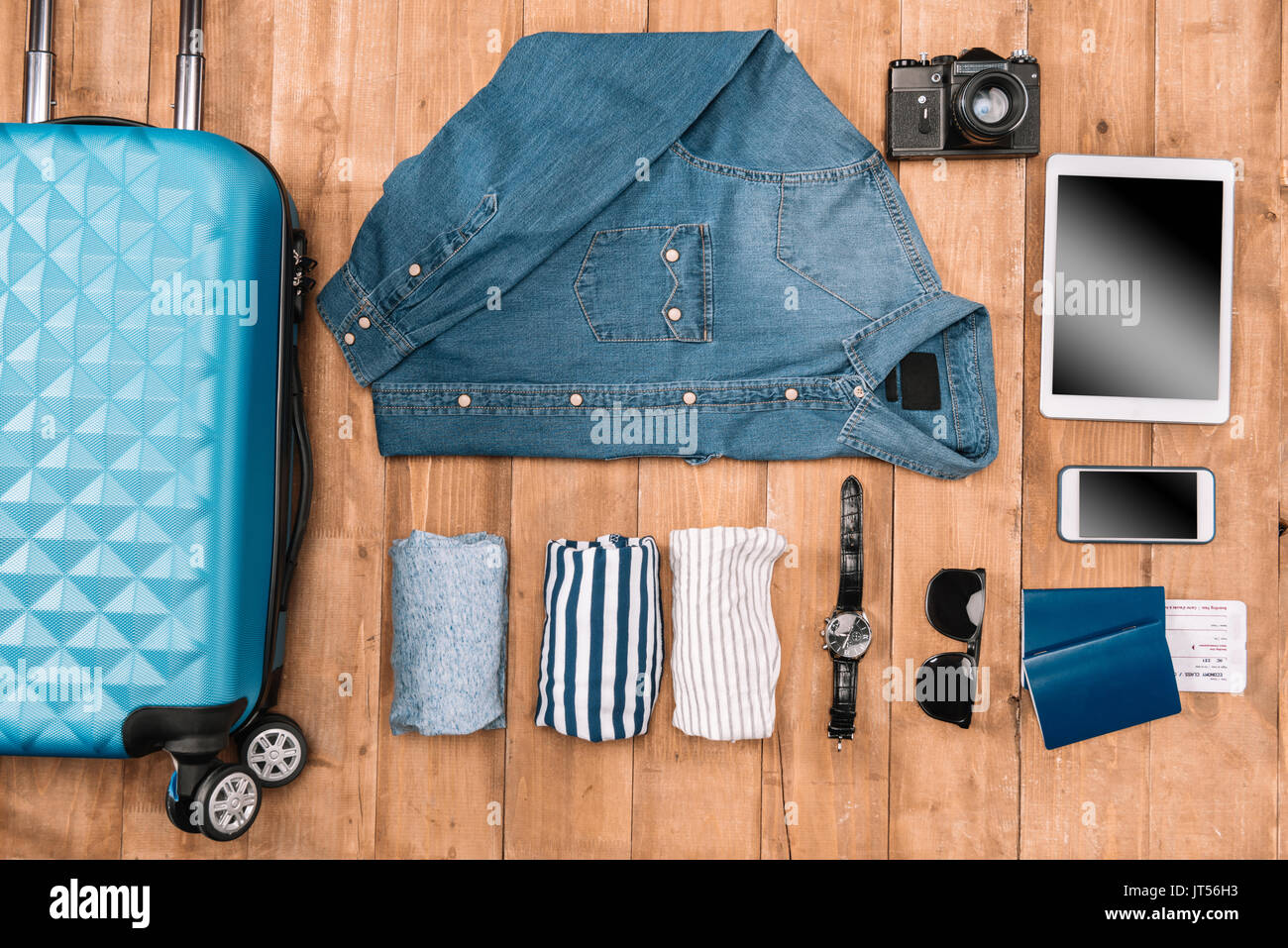 Flay lay von Business Urlaub Konzept mit Kleidung, Smartphone, Reisepass und Tickets auf Holzboden. Stockfoto