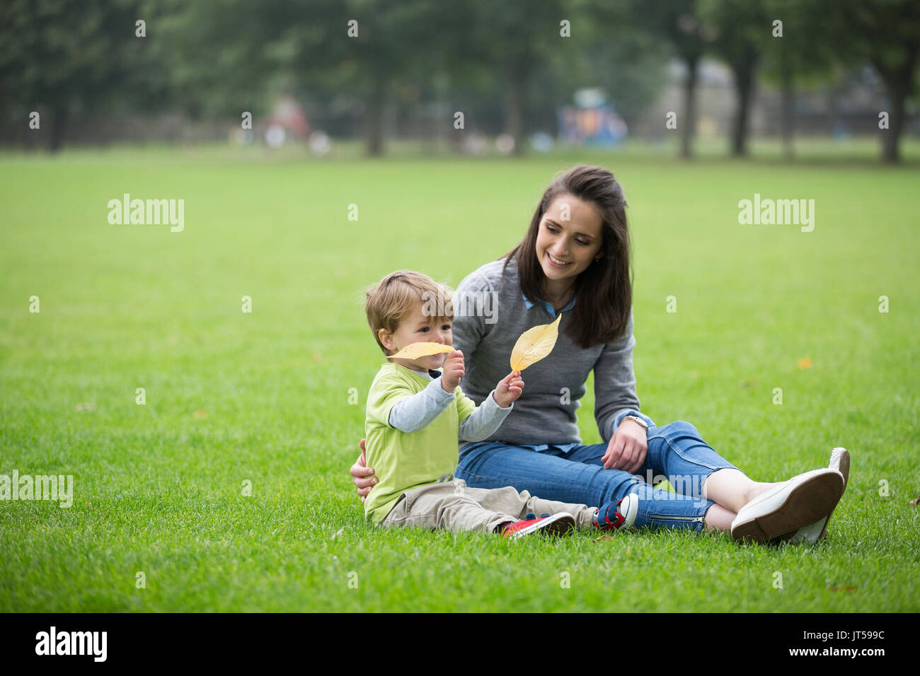 Glückliche Mutter spielt mit ihren Toddler Sohn im Freien. Liebe und Zweisamkeit Konzept. Stockfoto