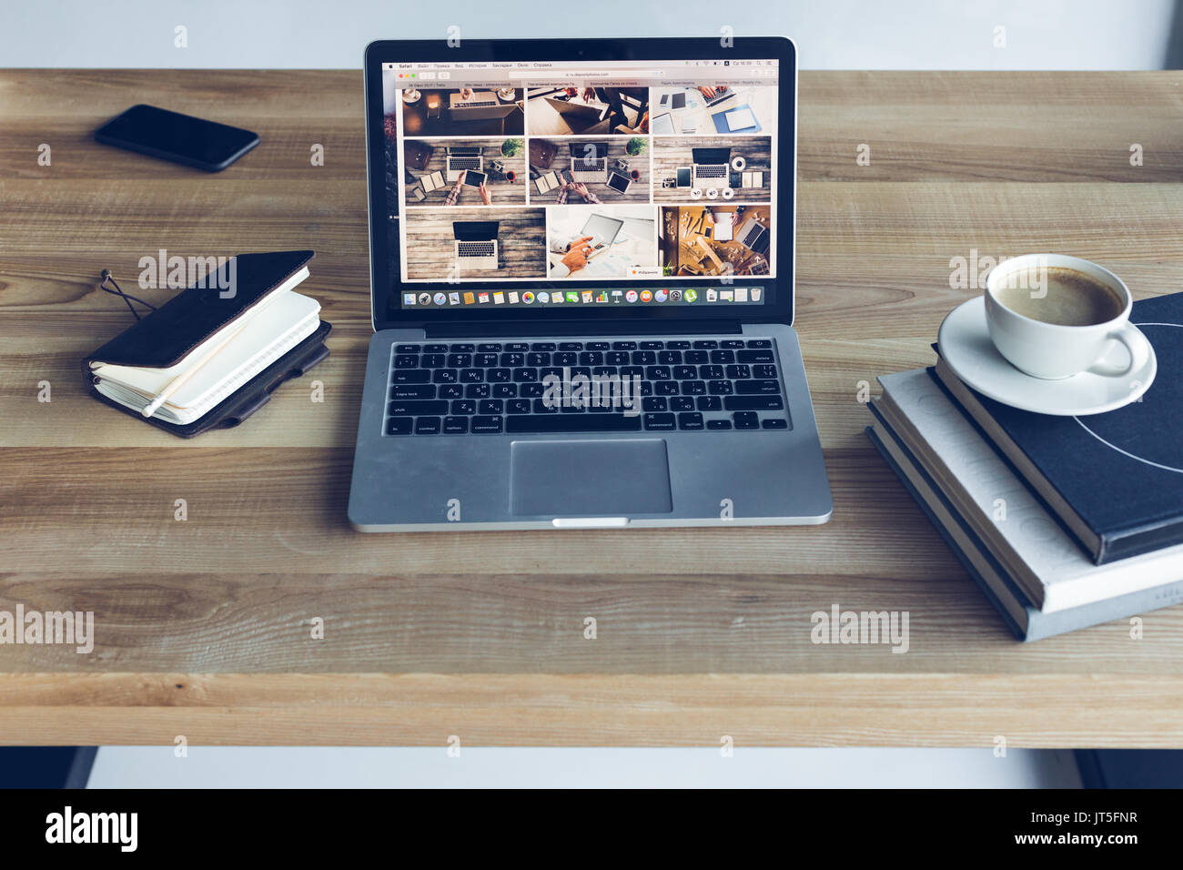 Laptop, Bücher und Kaffee in moderner Arbeitsplatz öffnen Stockfoto