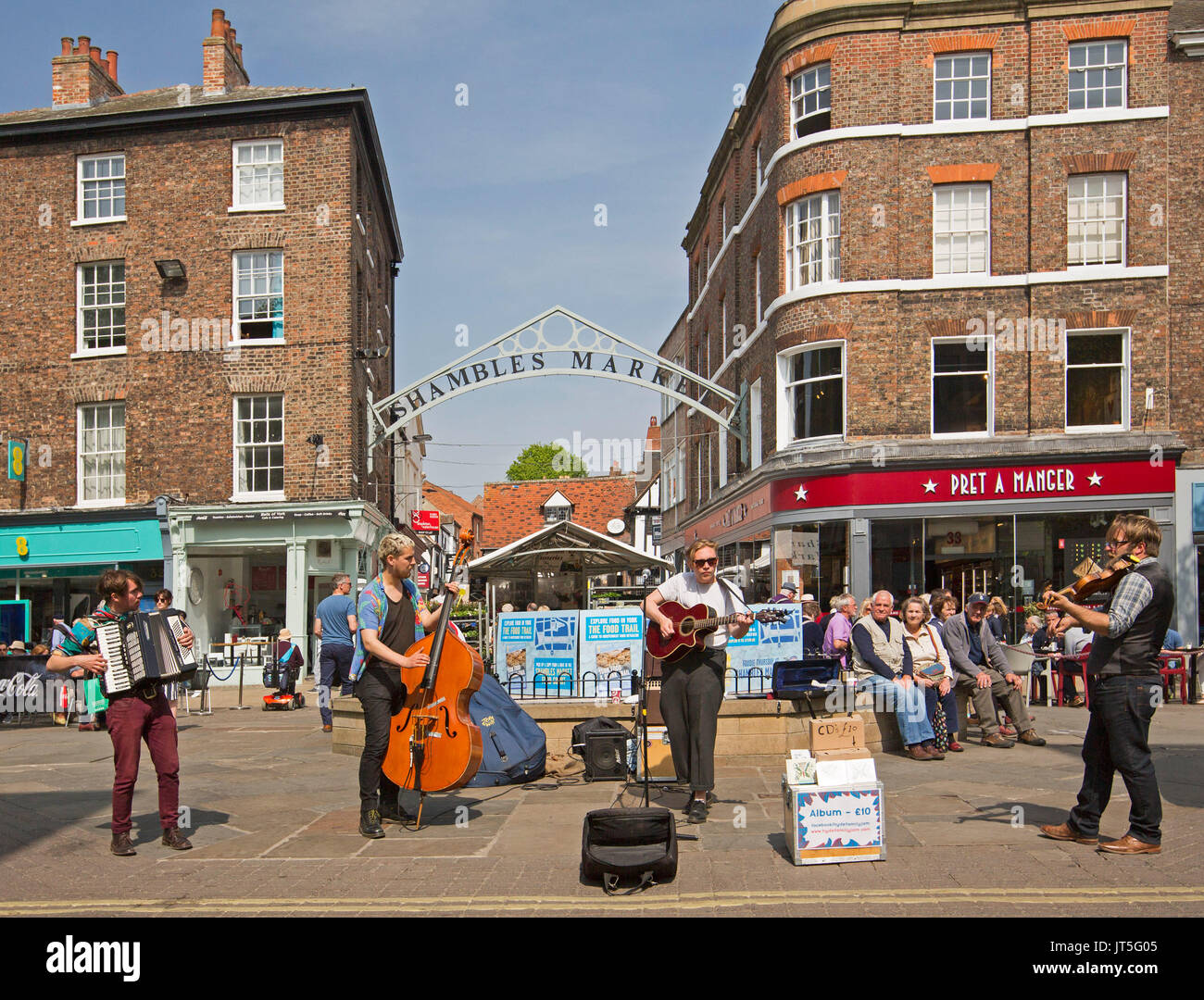 Gruppe von Musikern, die Hyde Familie, Straßenmusik neben dem Eingang zu den Trümmern mit Käufern genießen die freie Leistung in York, England, Stockfoto