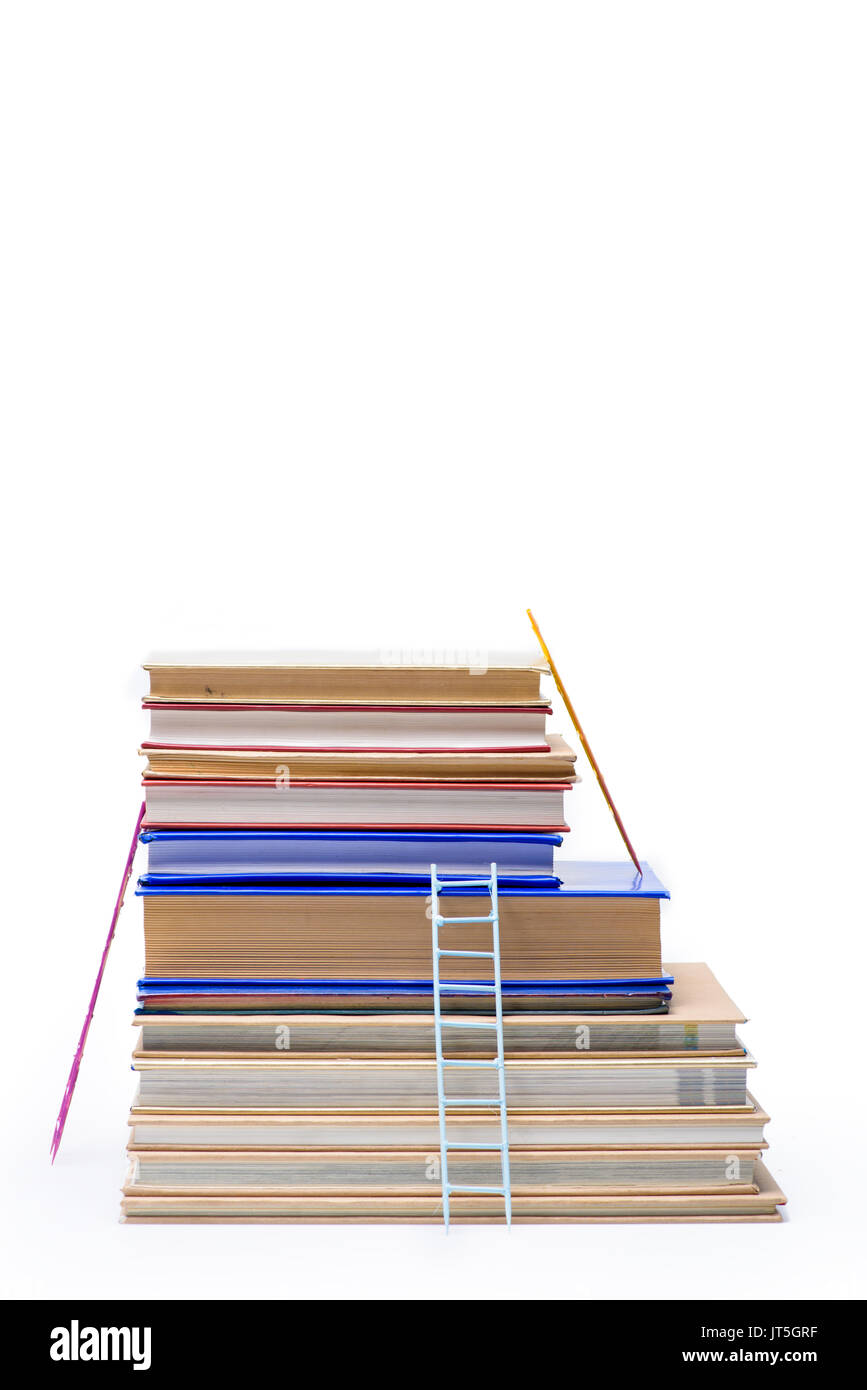 Stapel von Büchern mit Leitern auf Weiß, pädagogisches Konzept isoliert Stockfoto