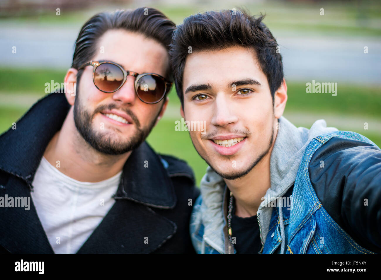 Zwei junge Männer, die die Selfie während draußen, Sicht von der Kamera selbst Stockfoto