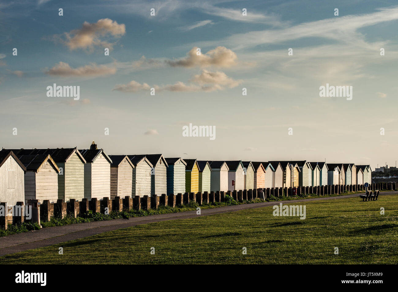 Reihe von bunten Badekabinen entlang Lancing Strand Grün in Lancing, West Sussex Stockfoto