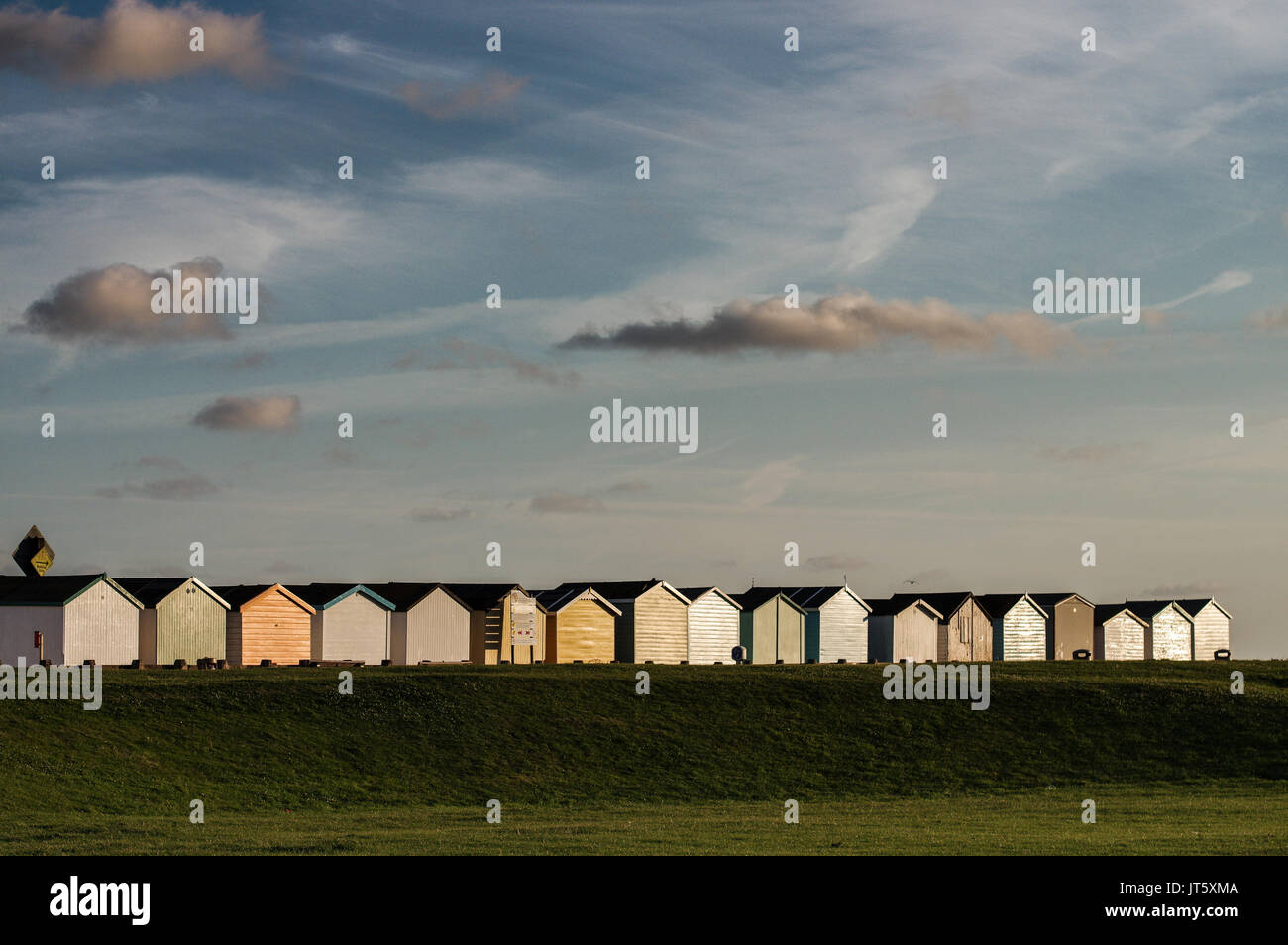 Reihe von bunten Badekabinen entlang Lancing Strand Grün in Lancing, West Sussex Stockfoto