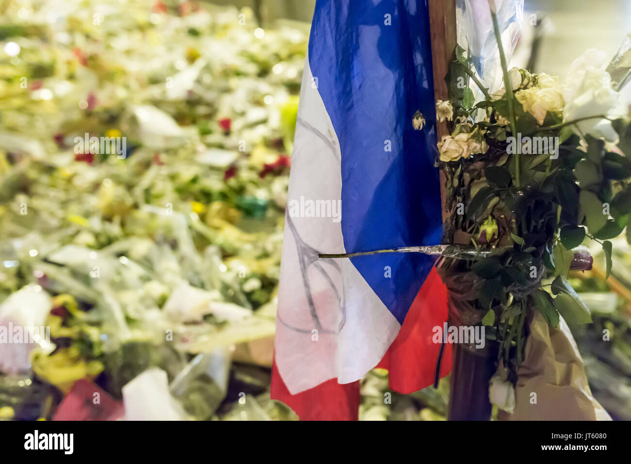 Französische Flagge unter den Blumen. Hommage an die Opfer der Terroranschläge in Paris, den 13. November 2015. Stockfoto
