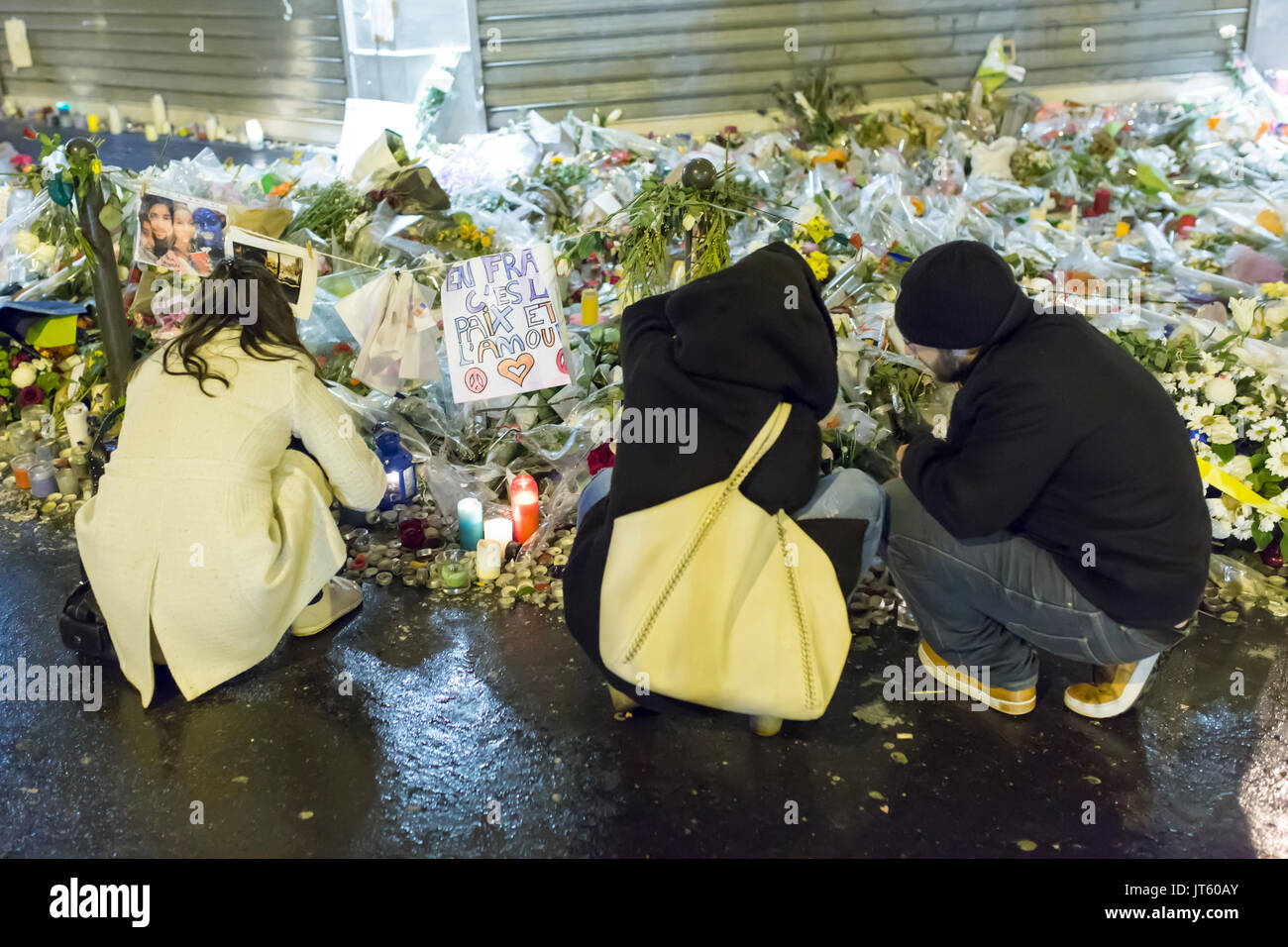 3 Personen kniete Trauer. Spontane Hommage an die Opfer der Terroranschläge in Paris, den 13. November 2015. Stockfoto