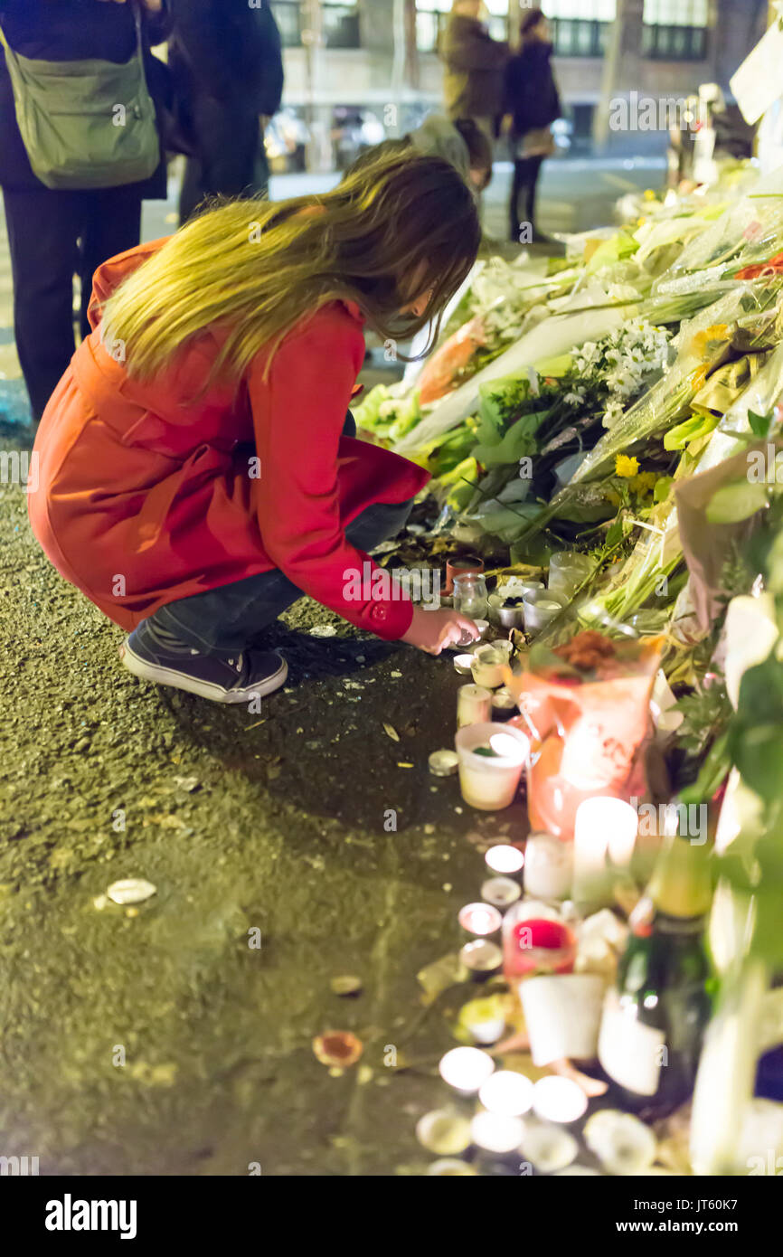 Spontane Hommage an die Opfer des Terroranschlags in Paris, 13. November 2015: Eine Frau wird eine Kerze anzünden Stockfoto