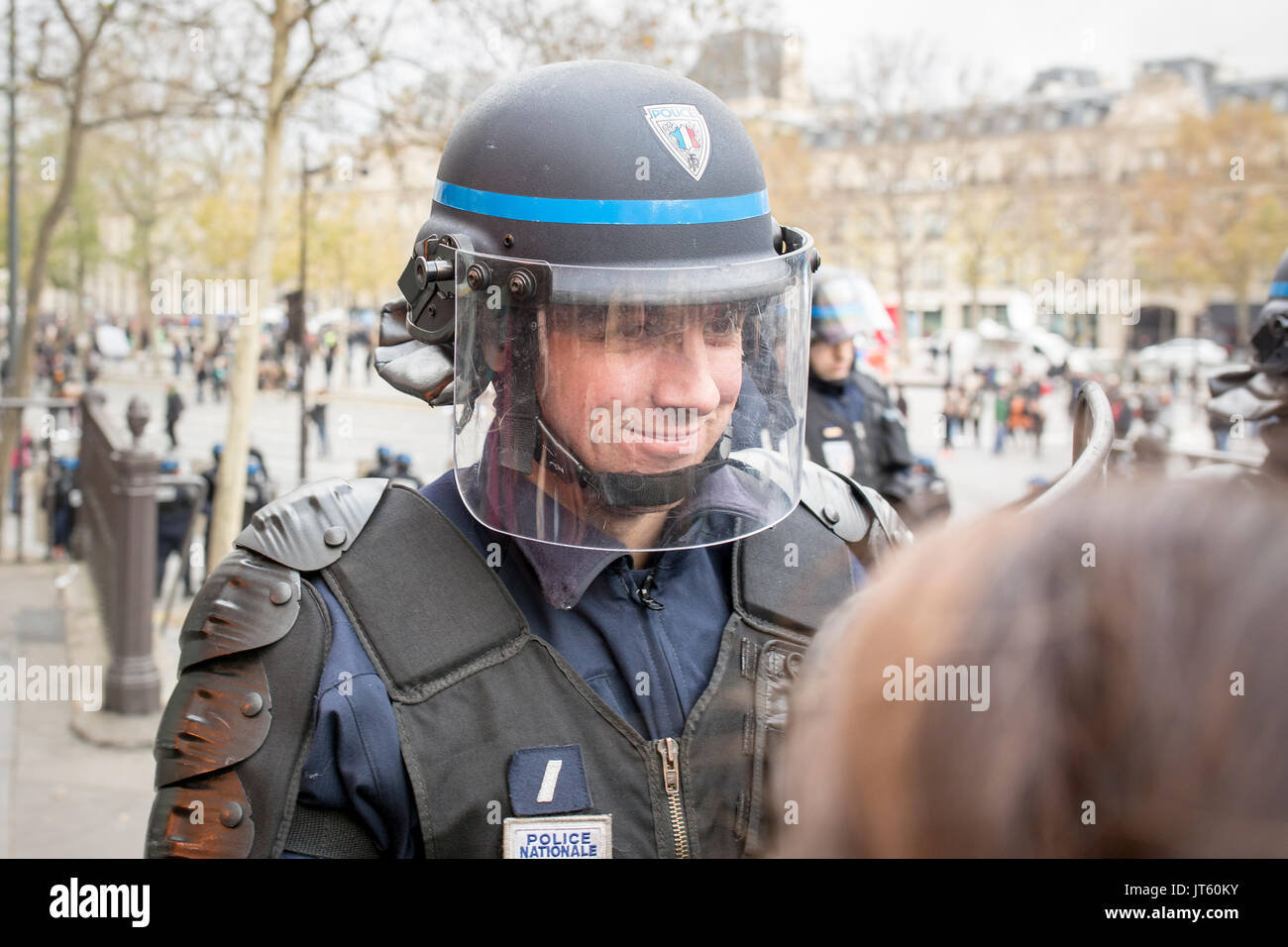 Französische Kartellbehörde Polizist lächelnd. Demonstrationen nach den Terroranschlägen im Paris der 13. November 2015: Stockfoto