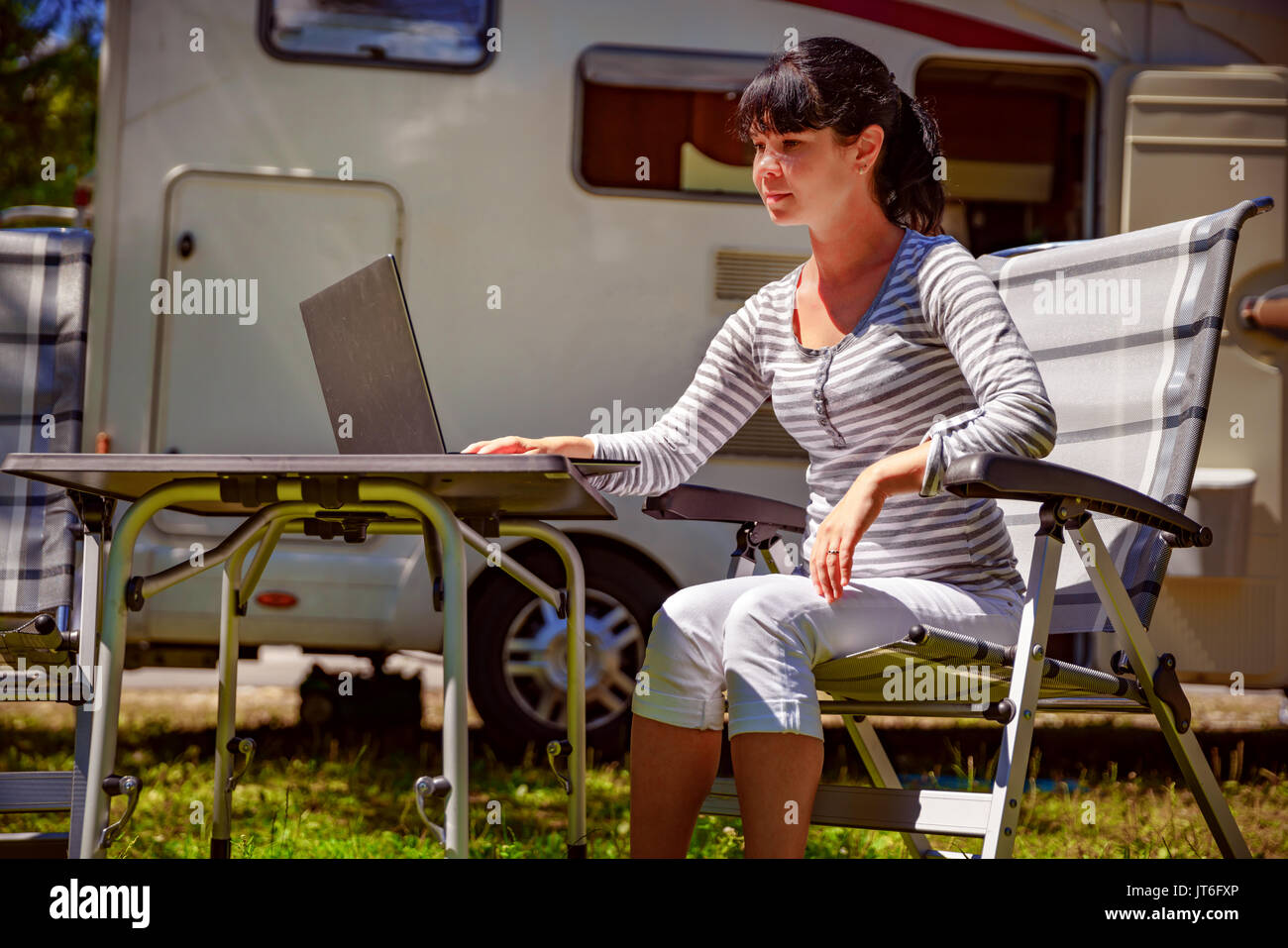 Frau auf dem Laptop in der Nähe des Camping. Caravan Auto Urlaub. Familie Urlaub Reisen, Urlaub im Reisemobil. Wi-fi-Anschluss Informationen c Stockfoto Frau auf dem Laptop in der Nähe des Camping. Caravan Auto Urlaub. Familie Urlaub Reisen, Urlaub im Reisemobil. Wi-fi-Anschluss Informationen c Stockfoto