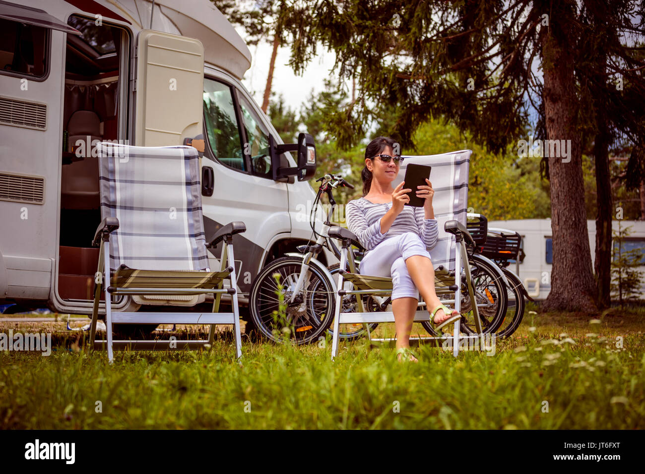 Frau auf dem Laptop in der Nähe des Camping. Caravan Auto Urlaub. Familie Urlaub Reisen, Urlaub im Reisemobil. Wi-fi-Anschluss Informationen c Stockfoto Frau auf dem Laptop in der Nähe des Camping. Caravan Auto Urlaub. Familie Urlaub Reisen, Urlaub im Reisemobil. Wi-fi-Anschluss Informationen c Stockfoto