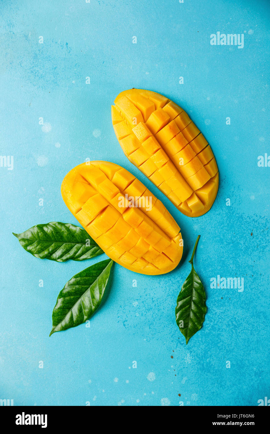 Rohe frische geschnittene Mango auf blauem Hintergrund Stockfoto