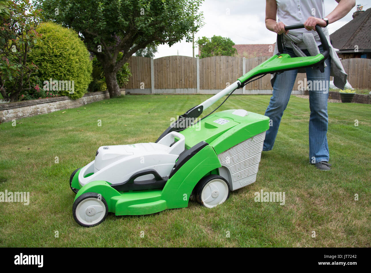 Ein leger gekleidete Frau Rasen Mähen mit einem VIKING MA 339 C Akku- rasenmäher. Offen. Sommer, UK Stockfotografie - Alamy