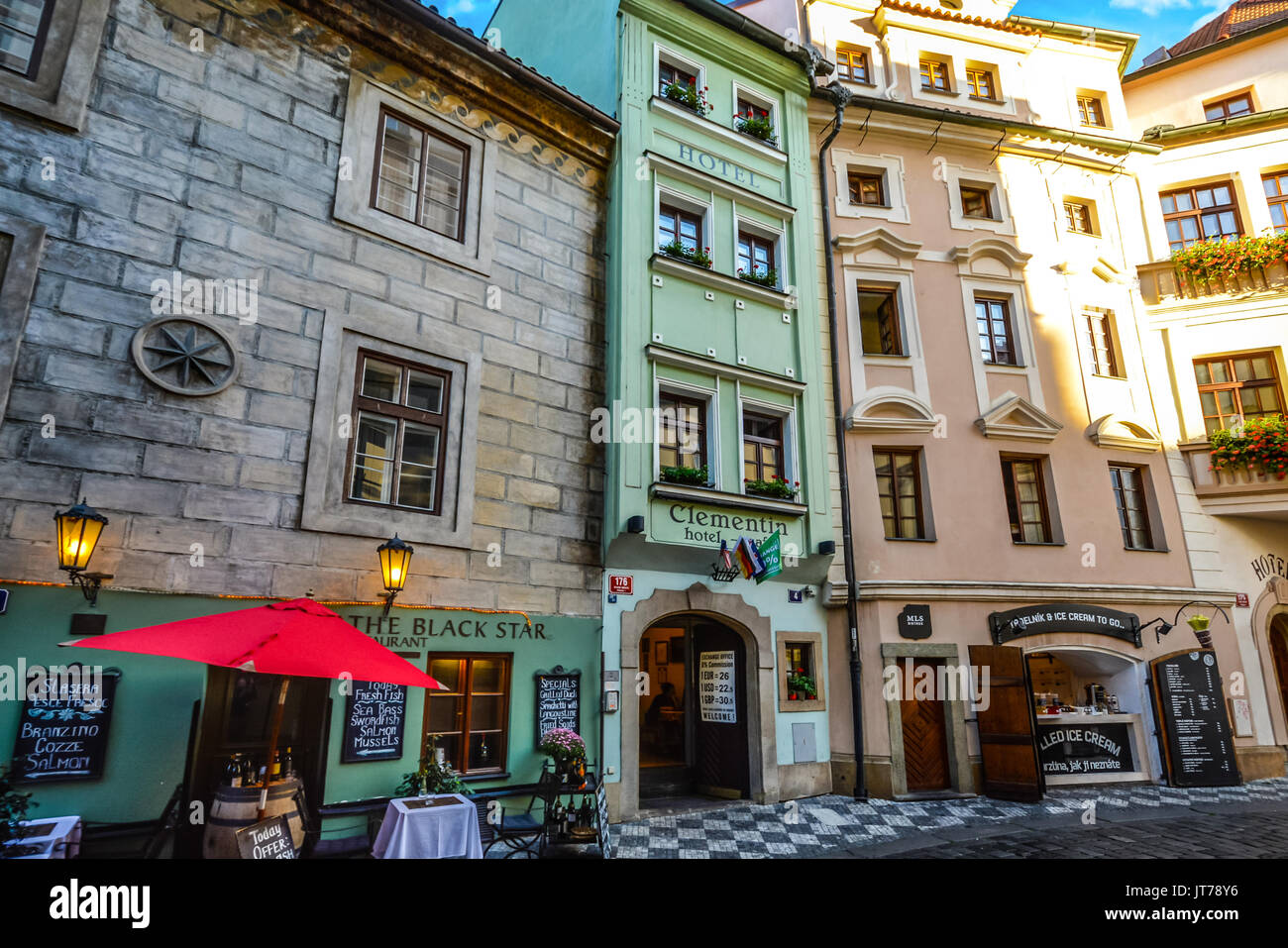 Eine sehr schmale, grüne Gebäude in der Altstadt von Prag mit einem kleinen Straßencafe und eine Garküche. Stockfoto