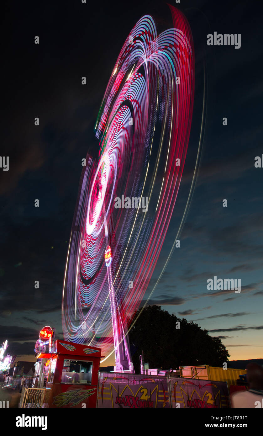 Genf. 8 Aug, 2017. Die lange Exposition Foto auf Aug 8, 2017 zeigt ein beleuchtetes Riesenrad auf einem Sommer Karneval am Ufer des Genfer See während der Genfer Festival in Genf, Schweiz, teil. Credit: Xu Jinquan/Xinhua/Alamy leben Nachrichten Stockfoto