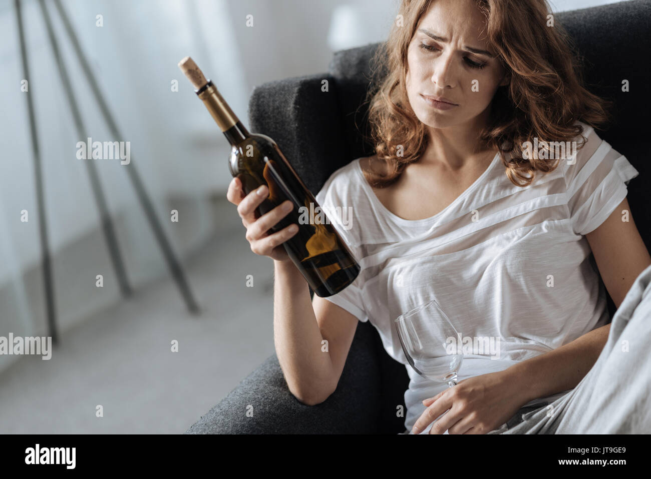 Freudlos moody Frau mit einer Flasche Wein Stockfoto