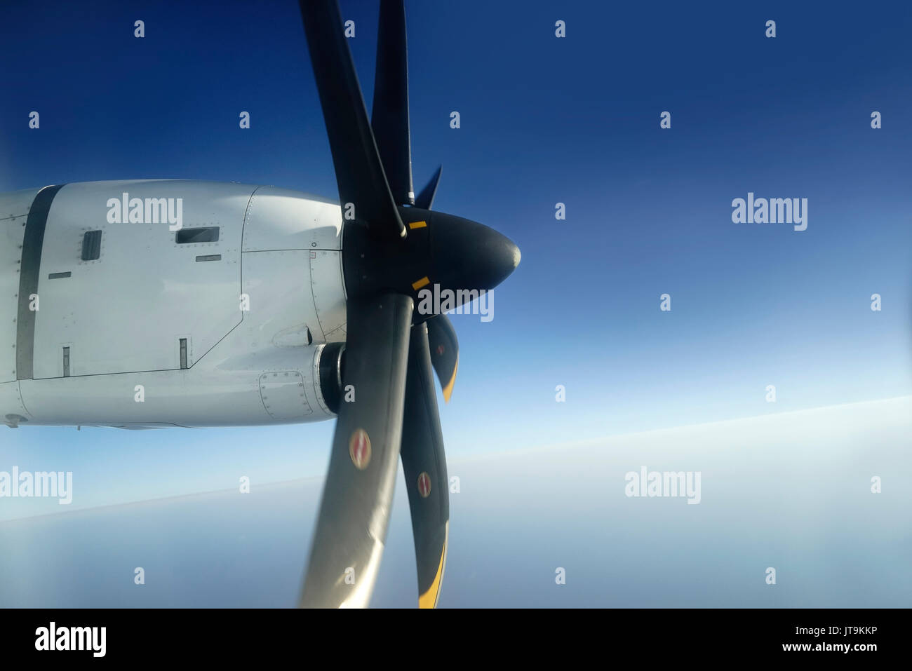 Außerhalb Aussicht vom Fenster Sitz des kleinen Flugzeug propeller Motor zu den Kotflügeln befestigt mit seinen schwarzen Klingen Drehen hoch in den blauen Himmel. Stockfoto