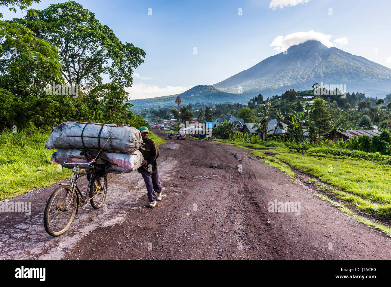 Mann, der eine Menge Gepäck auf dem Fahrrad, Virunga National Park in der Demokratischen Republik Kongo, Afrika Stockfoto