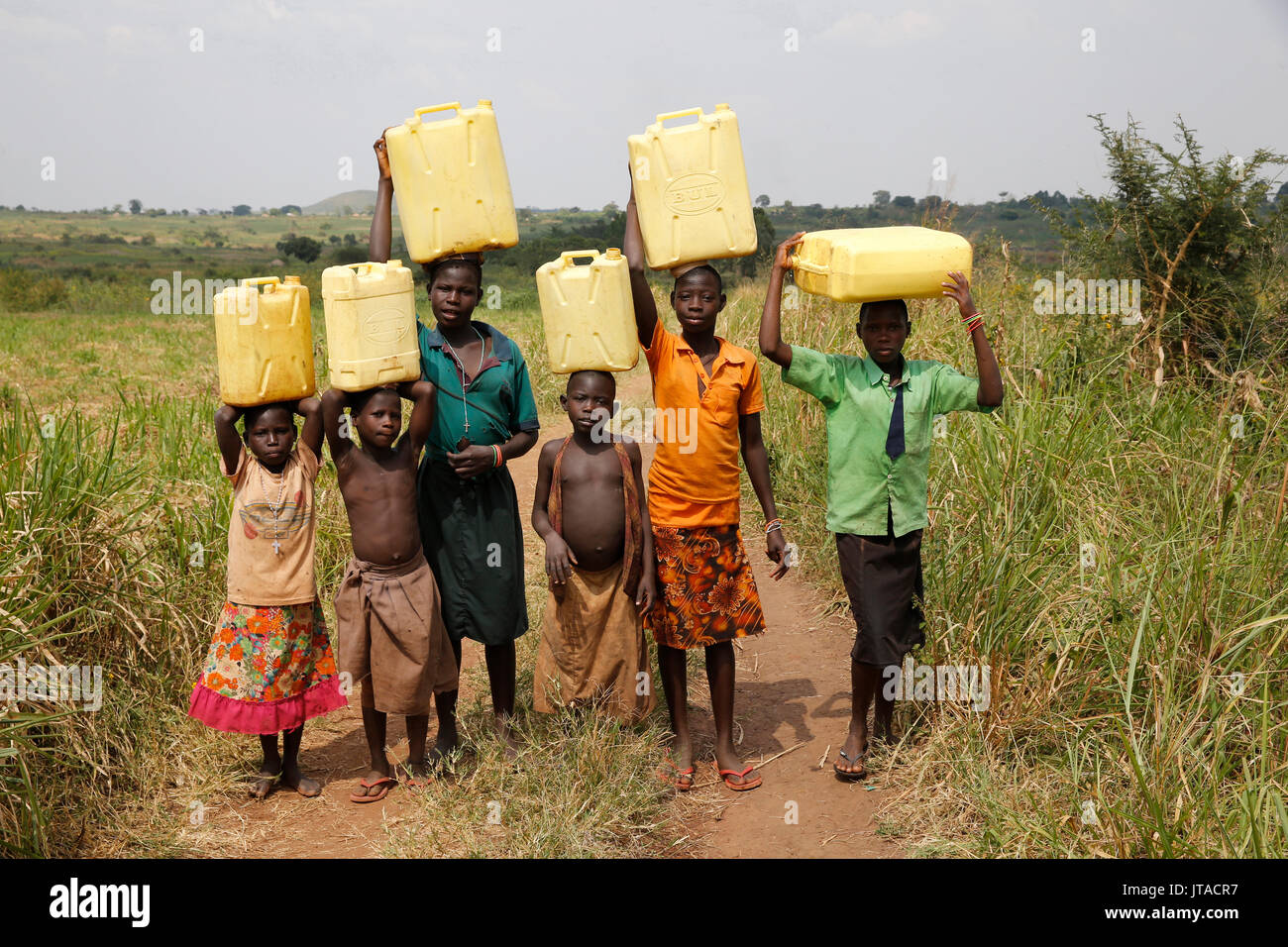 Ugandische Kinder Wasser holen, Masindi, Uganda, Afrika Stockfoto