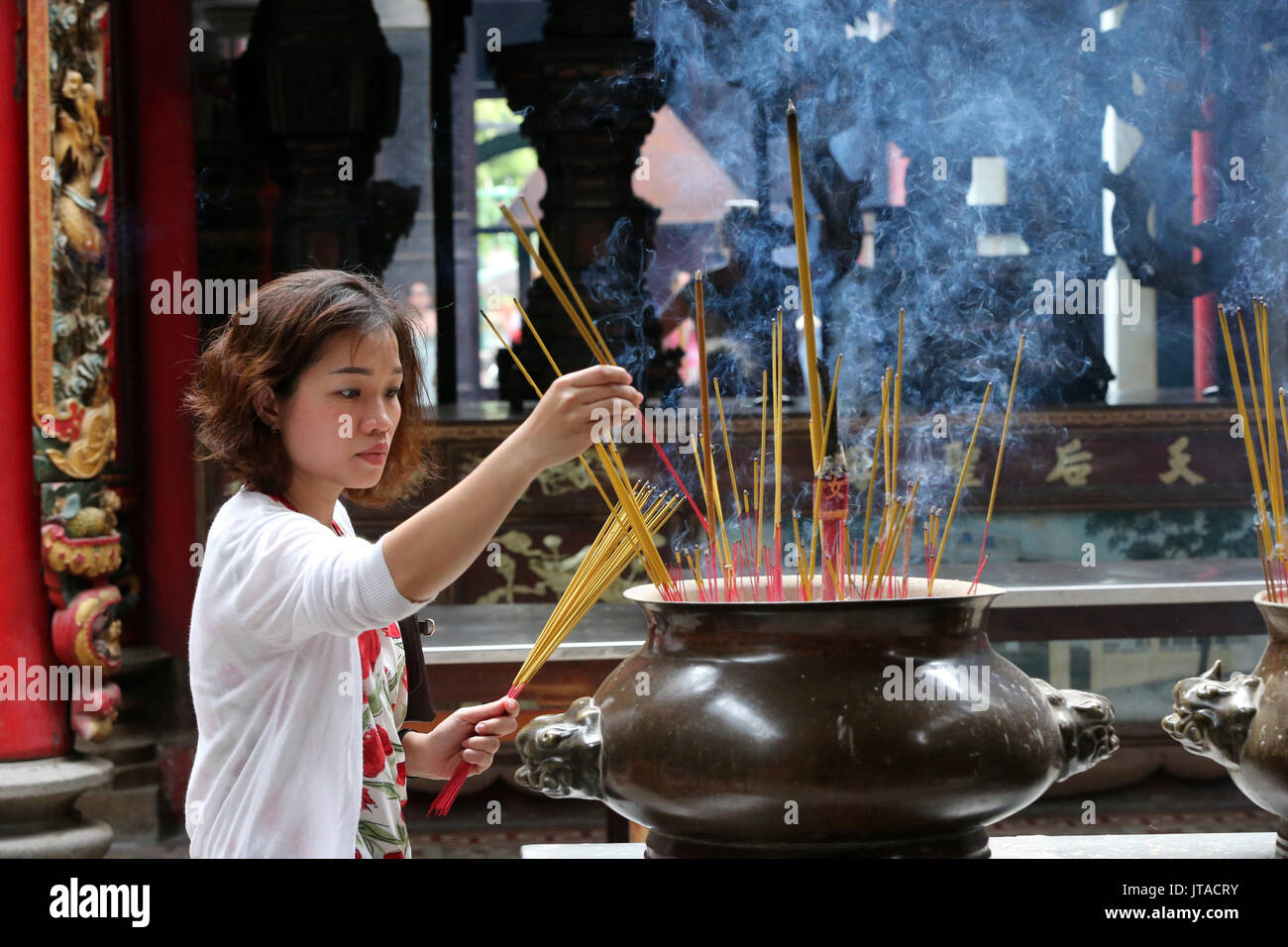 Buddhistische worshipper Inverkehrbringen Räucherstäbchen auf Joss stick Topf, taoistischen Tempel, Phuoc ein Hoi Quan Pagode, Ho Chi Minh City, Vietnam Stockfoto