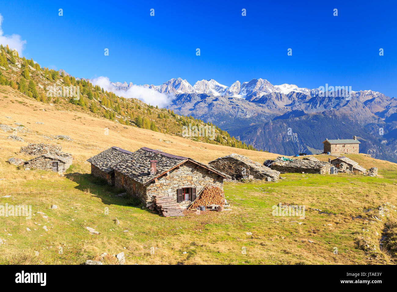 Berghütten durch die schneebedeckten Gipfel der Berninagruppe, Arcoglio Alp, Val Malenco Torreggio, Valley, Valtellina, Lombardei, Italien gerahmt Stockfoto