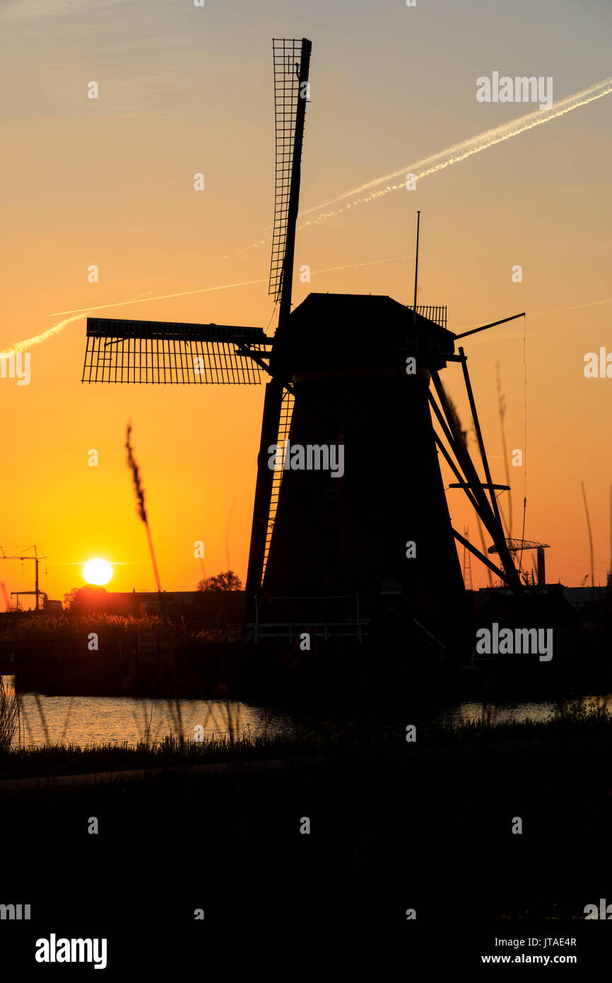 Silhouette der typische Windmühle umrahmt von den feurigen Himmel bei Sonnenuntergang, Kinderdijk, UNESCO, Molenwaard, Südholland, Niederlande Stockfoto