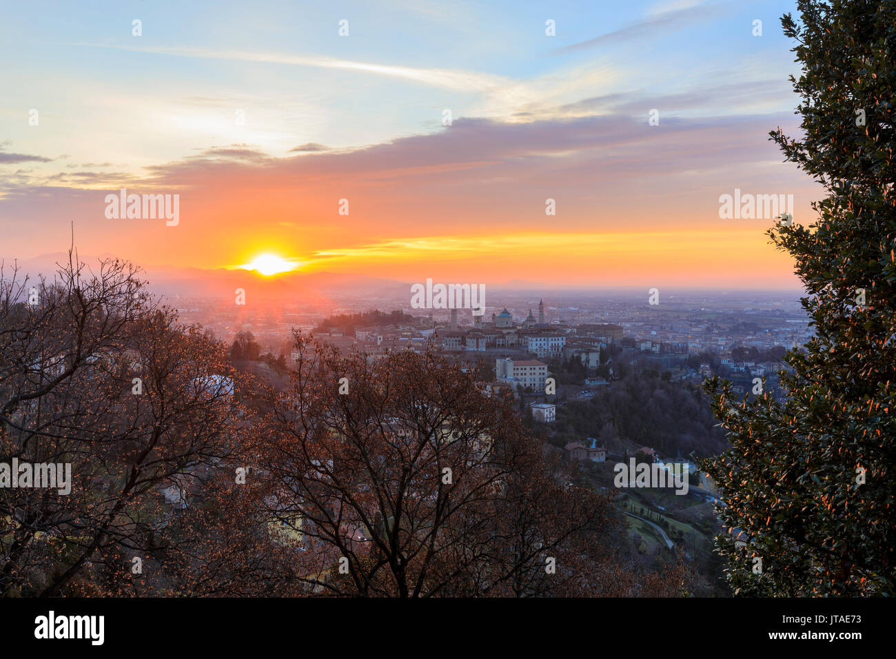 Blick auf die mittelalterliche Altstadt Citta Alta auf dem Hügel von den Fiery orange sky in der Morgendämmerung, Bergamo, Lombardei, Italien Stockfoto