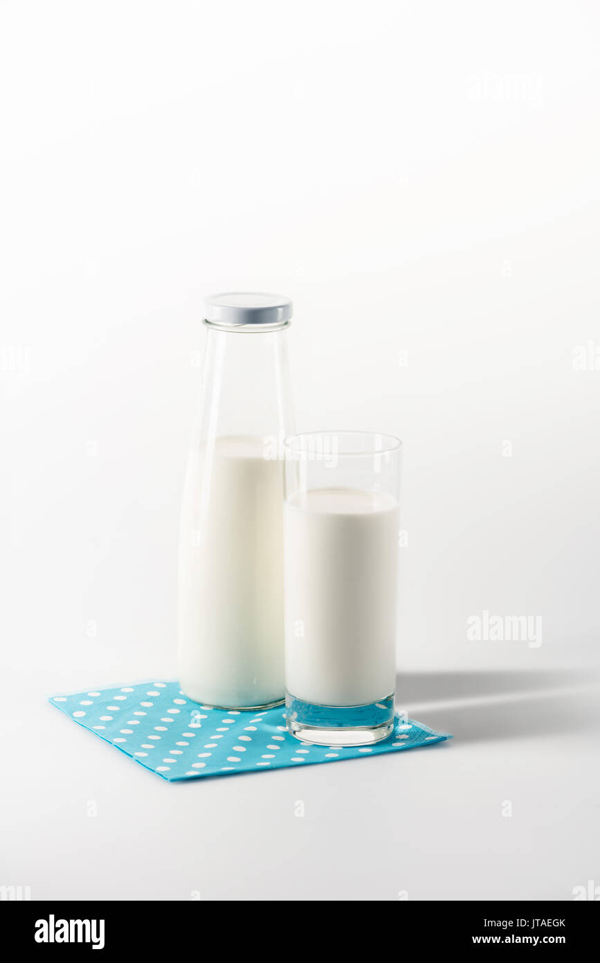 Milch in Glas und Flasche auf Serviette mit Kopie Raum auf Weiß isoliert Stockfoto