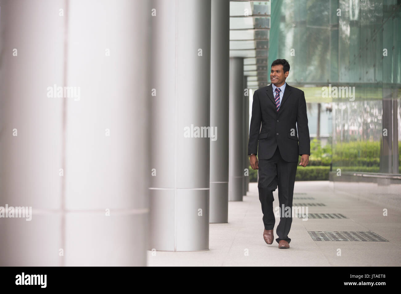Indische Geschäftsmann in einer asiatischen Stadt. Porträt eines asiatischen Geschäftsmann lächelnd und weg von der Kamera. Stockfoto