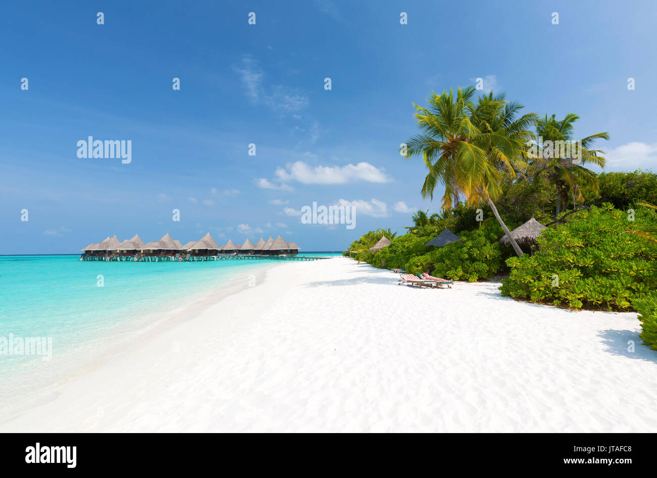 Blick entlang tropischer Strand in Richtung über dem Wasser Villen, Coco Palm Dhuni Kolhu Resort, Baa Atoll, Malediven Stockfoto