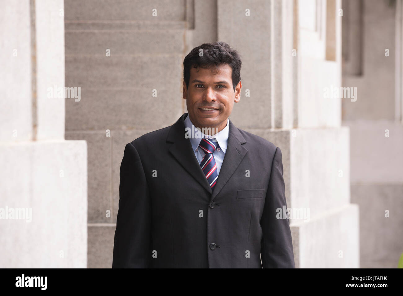 Indische Geschäftsmann in einer asiatischen Stadt. Porträt eines asiatischen Geschäftsmann lächelt und schaut in die Kamera. Stockfoto