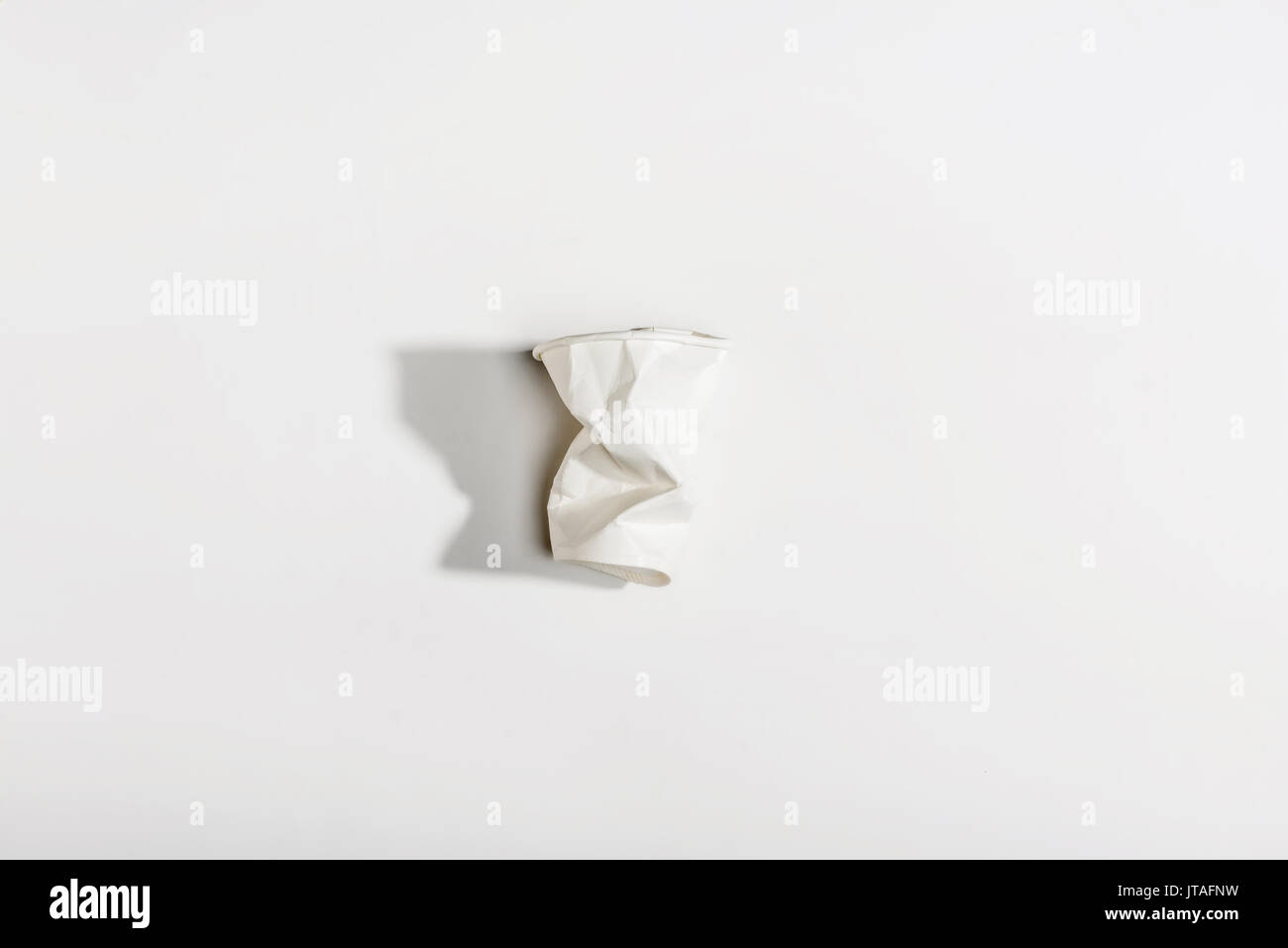 Blick von oben auf ein zerknittertes Papier Becher isoliert auf weißem Stockfoto