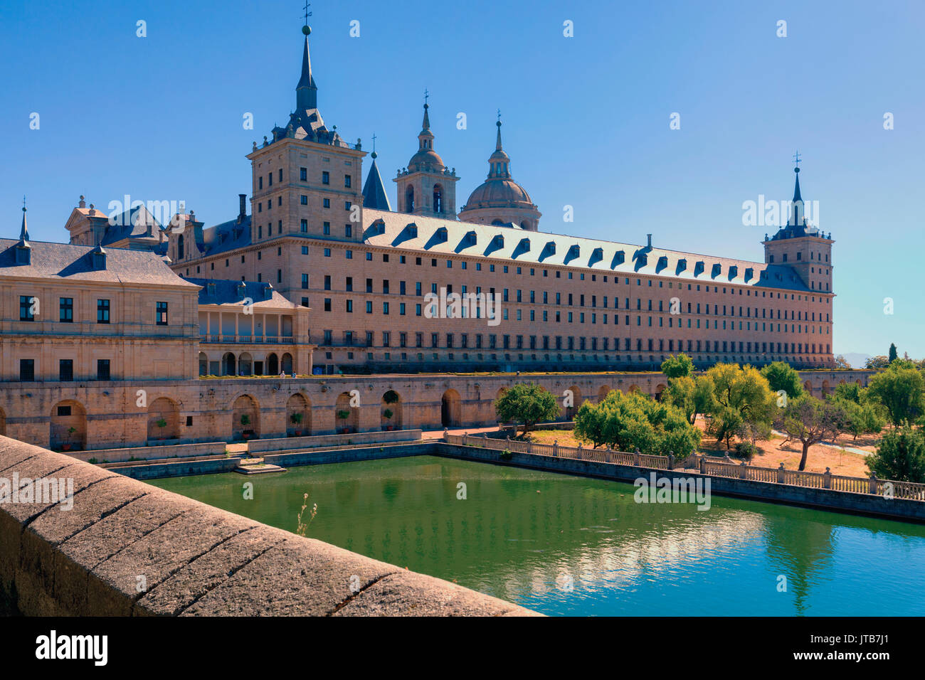 San Lorenzo de El Escorial, Madrid, Spanien. Das Kloster von El Escorial über den Garten Teich gesehen. Das Kloster und seine historischen surroundi Stockfoto
