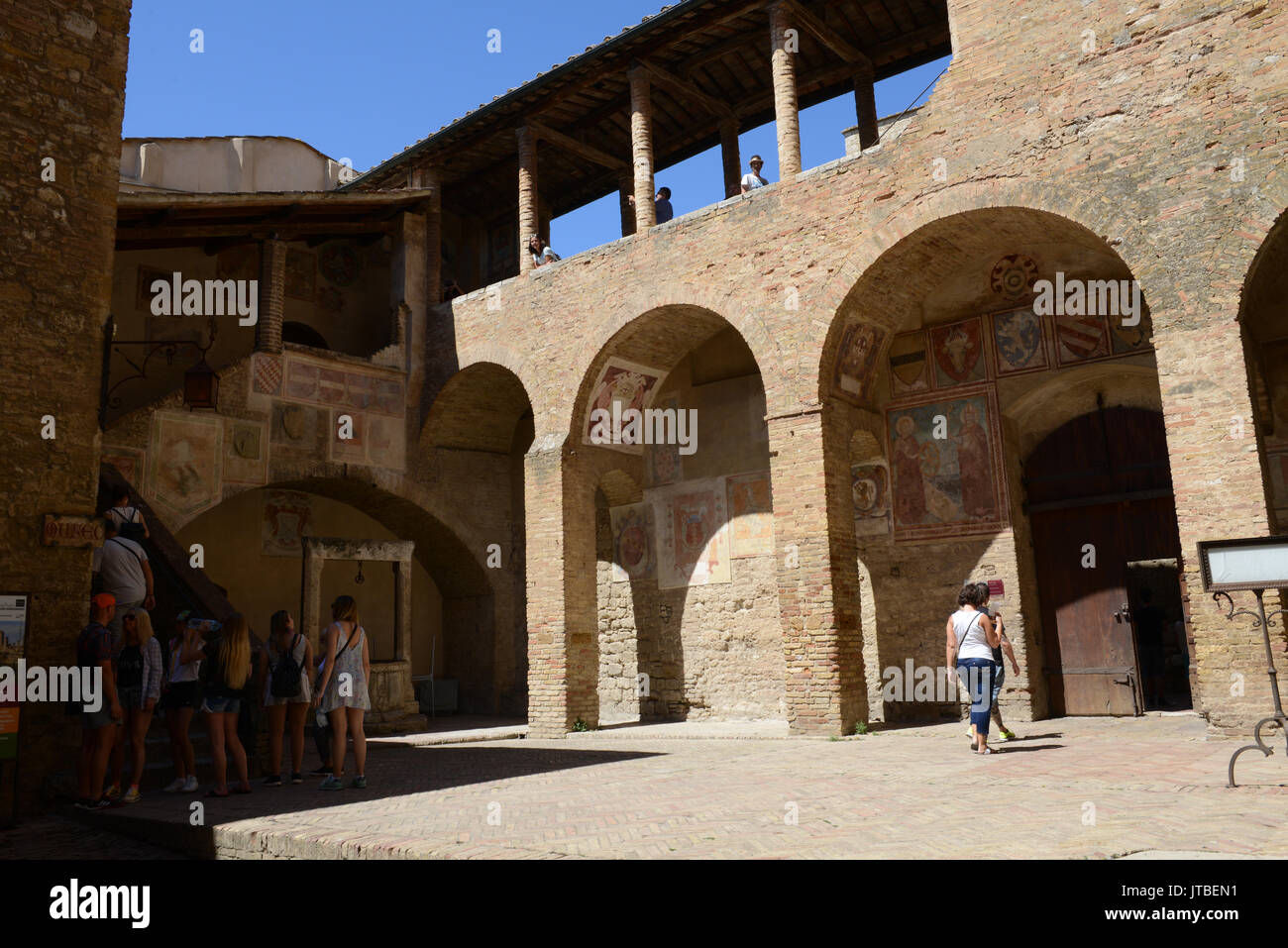 San Gimignano, Italien - 6. Juli 2017: Die Leute, die zu Fuß das Alte Rathaus in San Gimignano in Italien Stockfoto