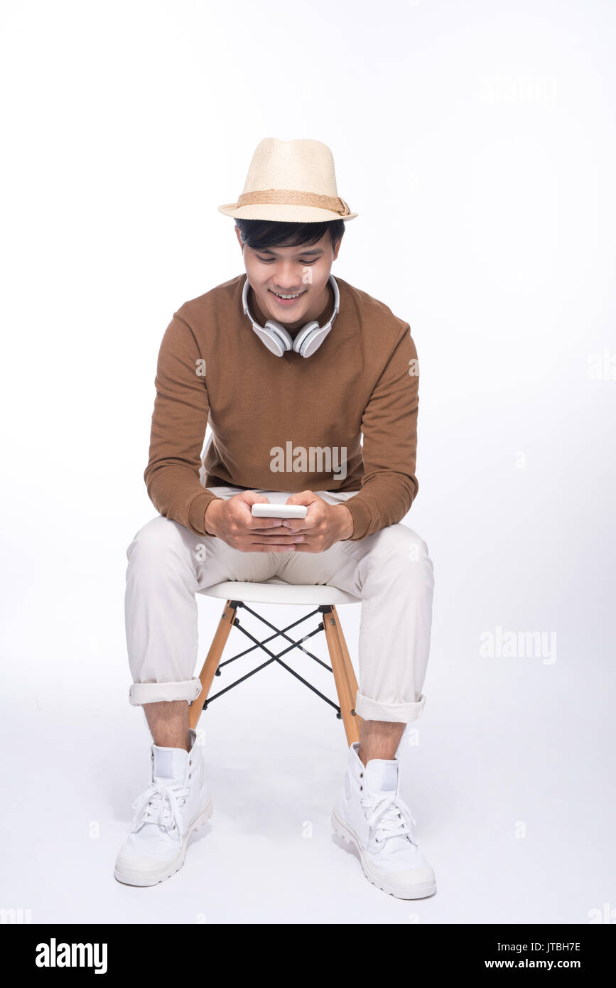 Smart casual asiatischer Mann sitzend auf Stuhl im Studio-Hintergrund Stockfoto